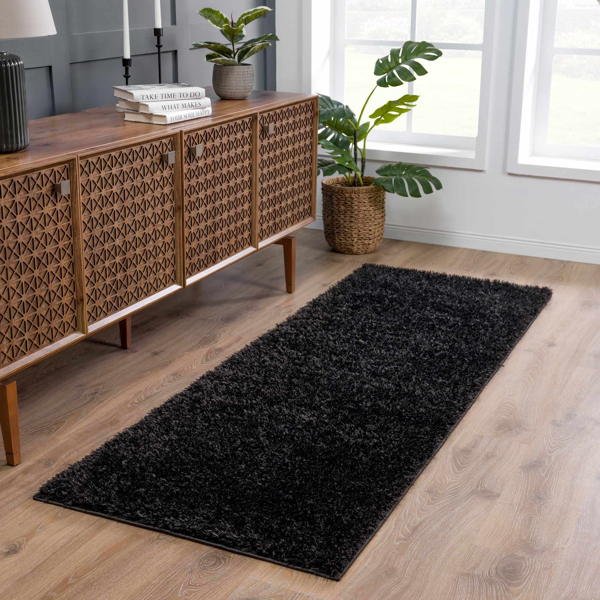 Alfombra peluda Faina de color negro liso lavable