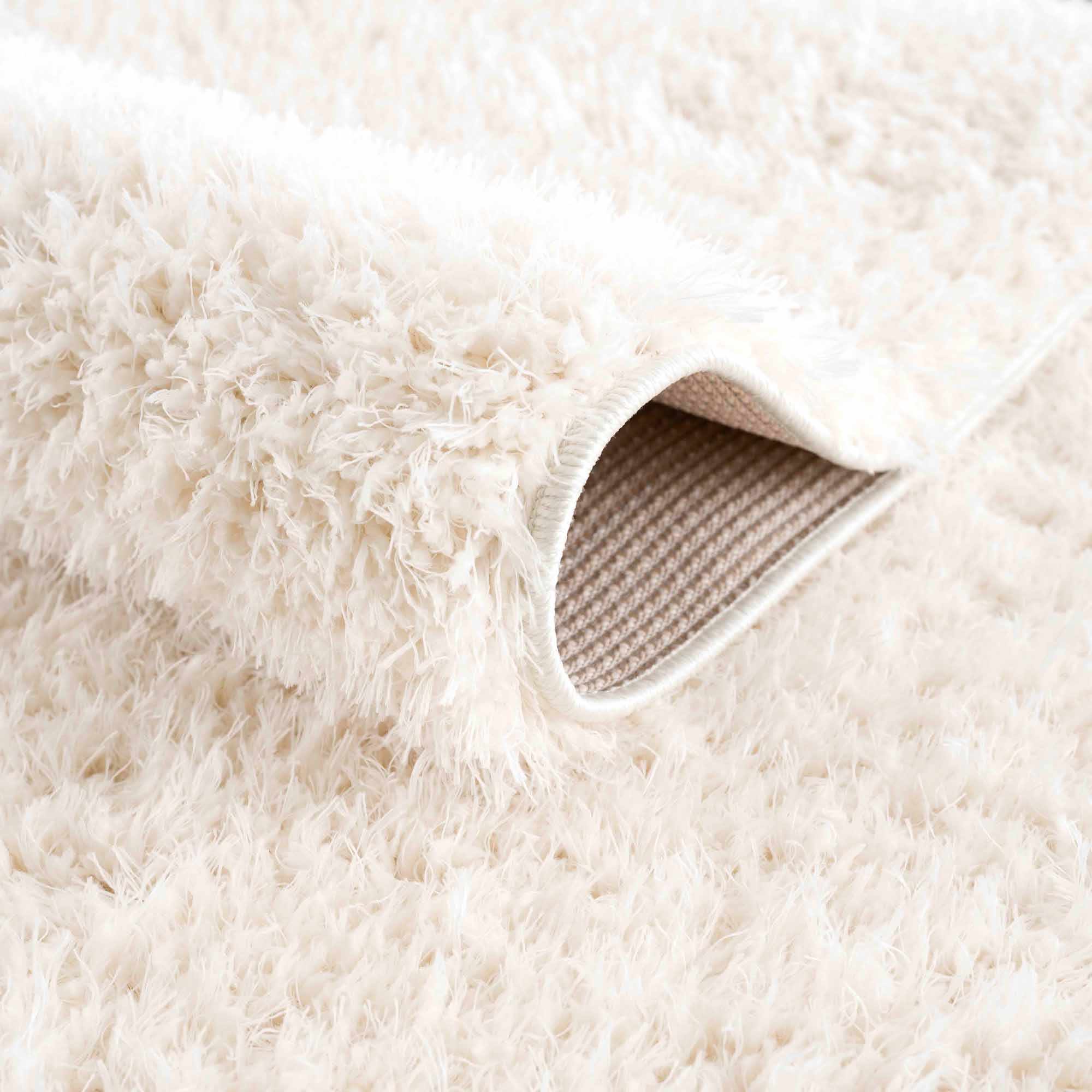 Alfombra peluda Faina de color crema sólido lavable