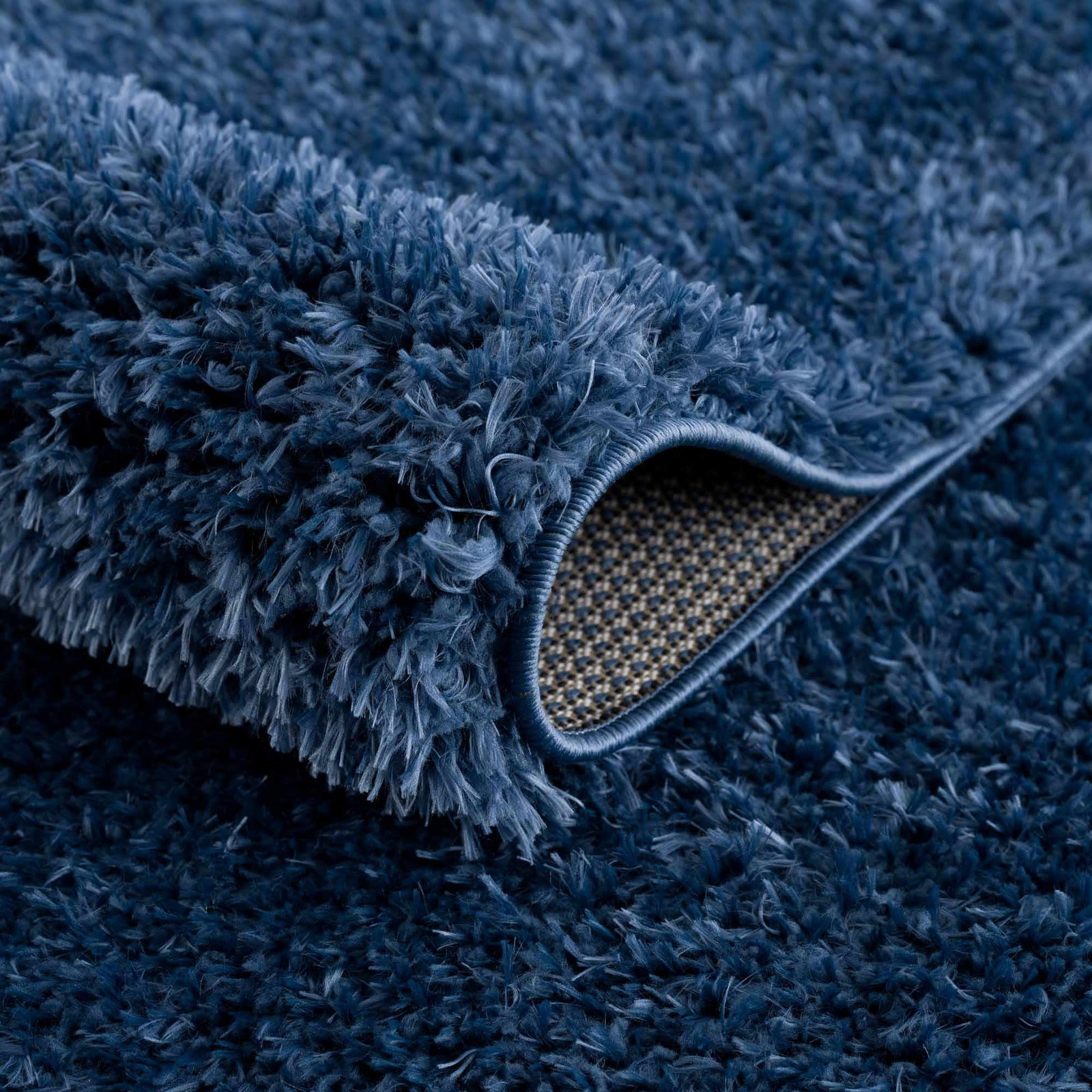 Alfombra peluda Faina de color azul oscuro liso lavable